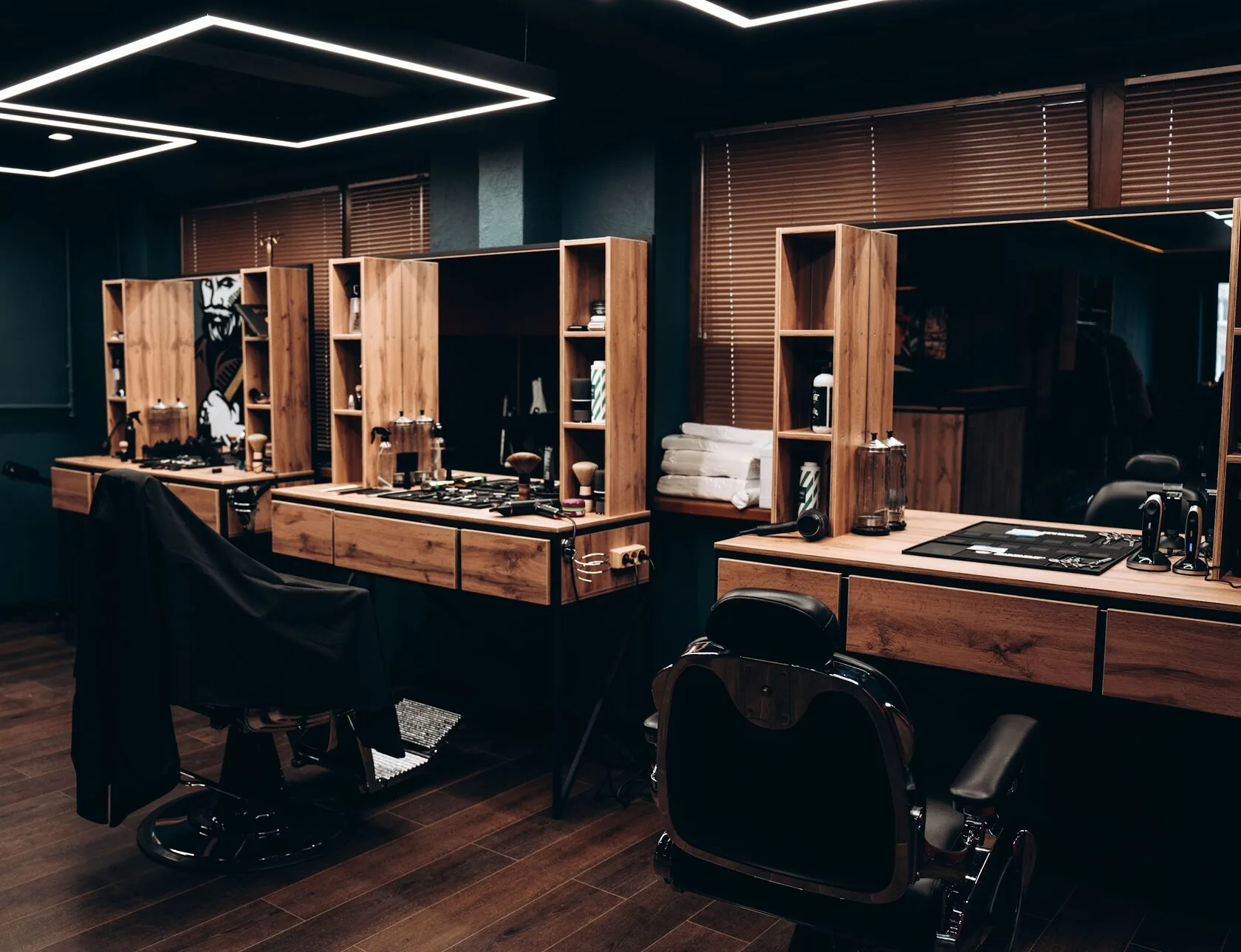 Интерьер зала Director Barbershop: рабочие места, дерево, зеркала