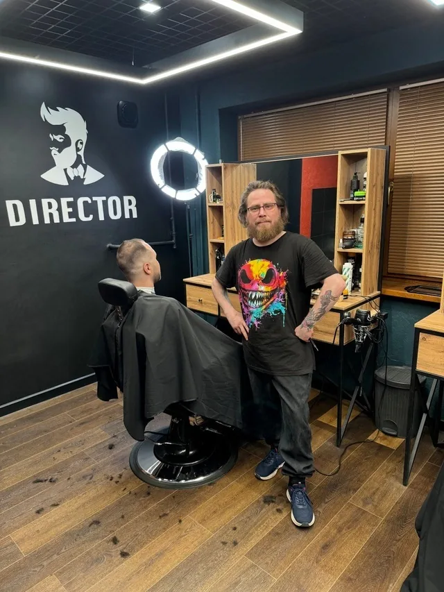 Стрижка в кресле у стены с логотипом Director